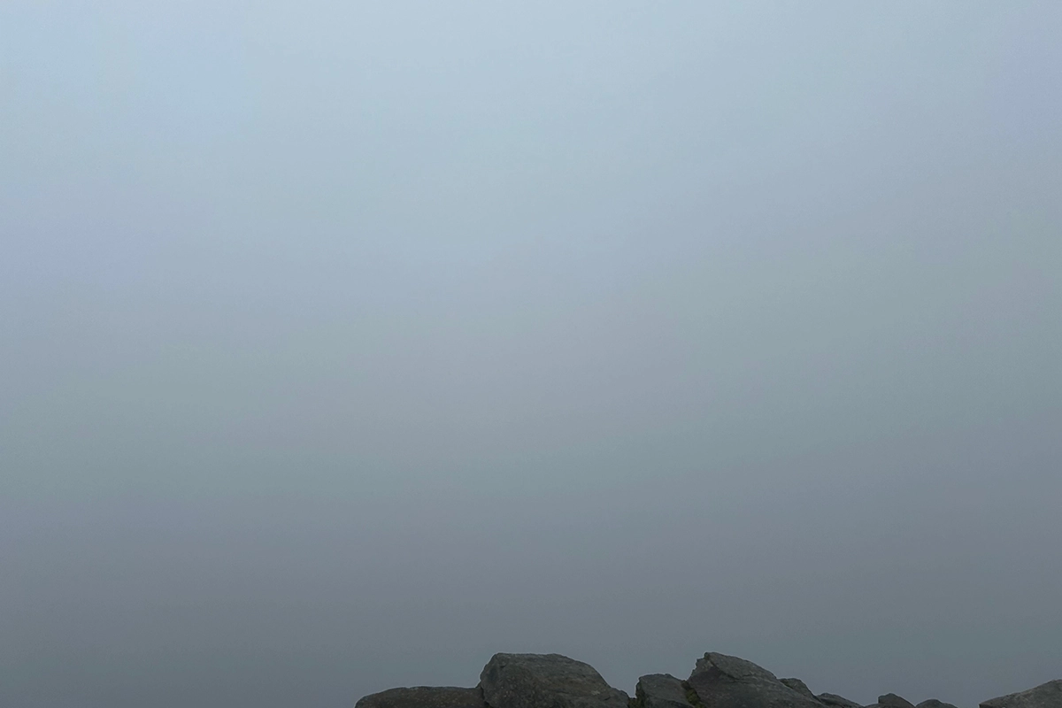 a misty view from the top of a mountain in wales