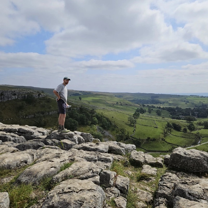 Liam on top of Malham Cove looking out at the village