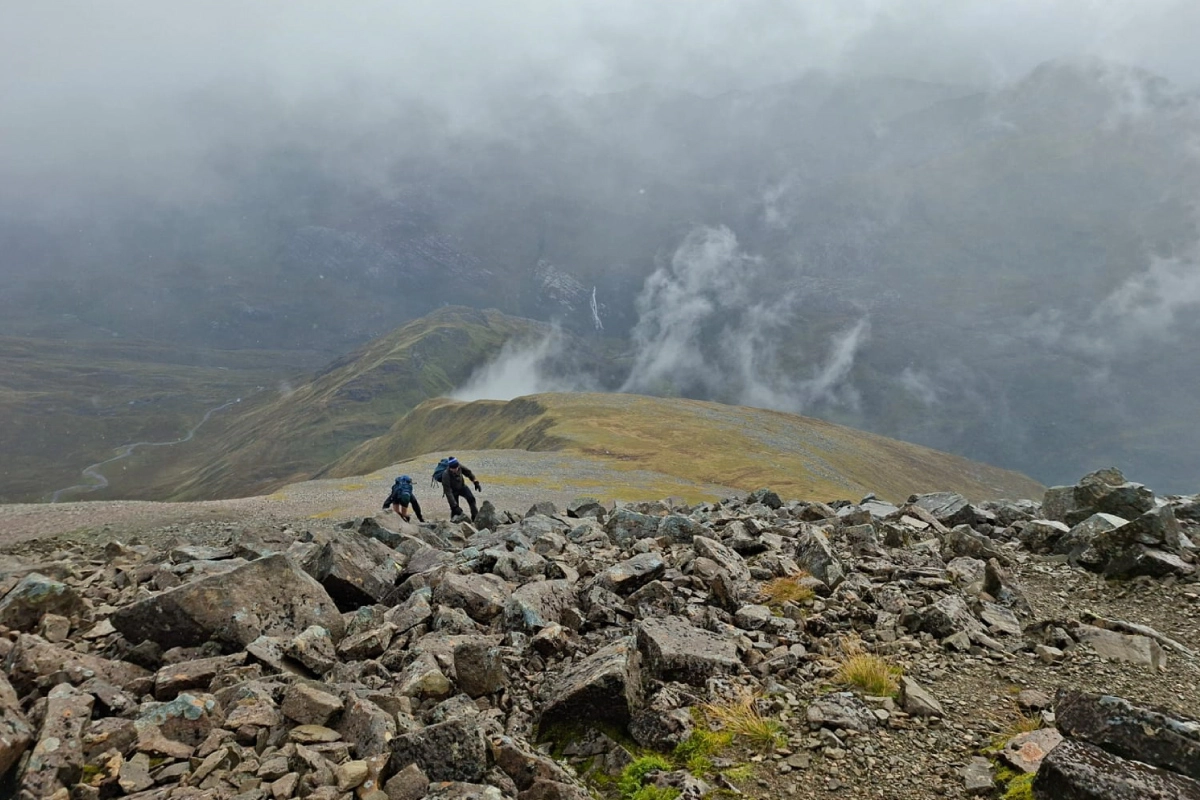 Looking down Ben Nevis south face as two people scramble up