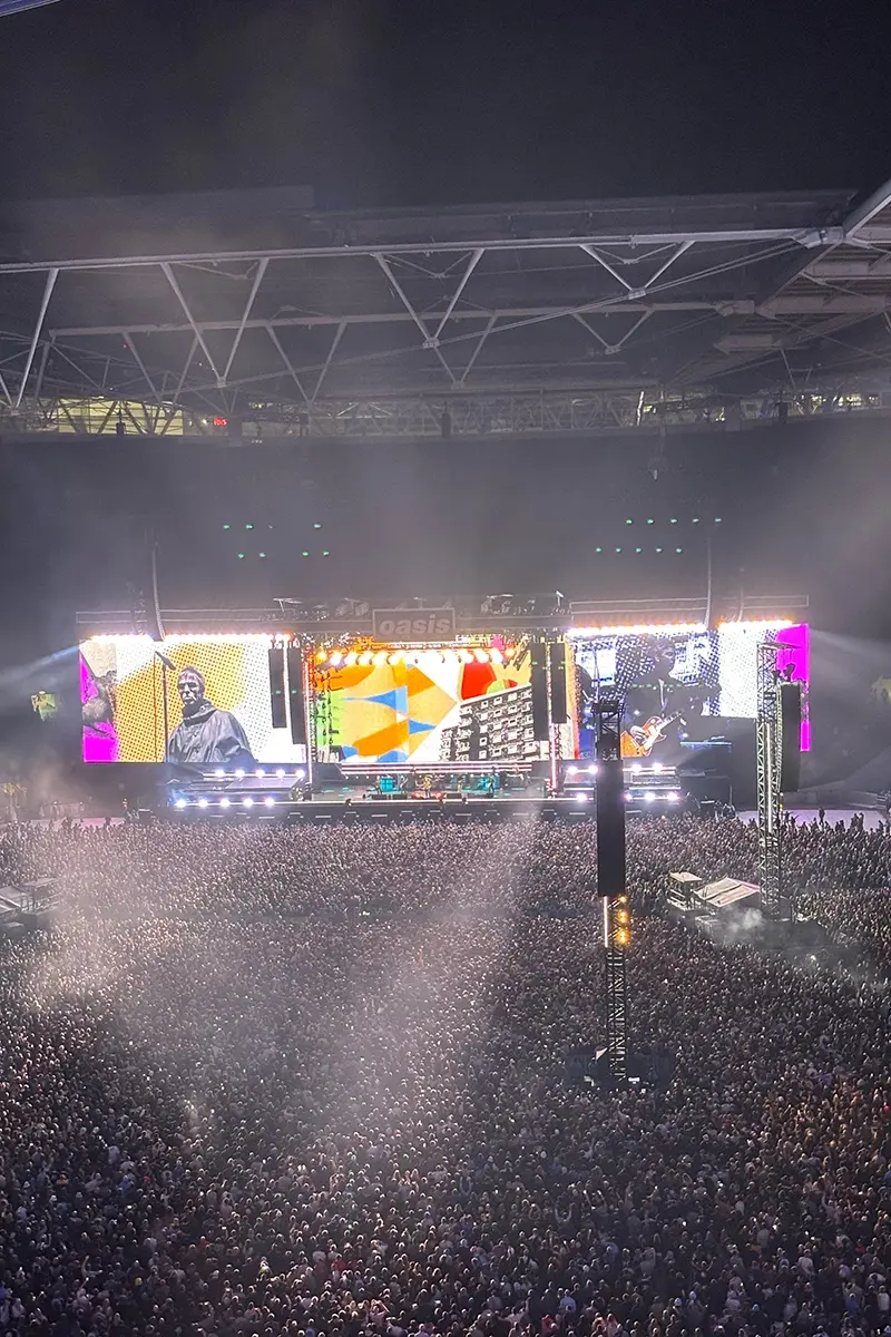 Oasis performing at Wembley with Noel and Liam visible on screen