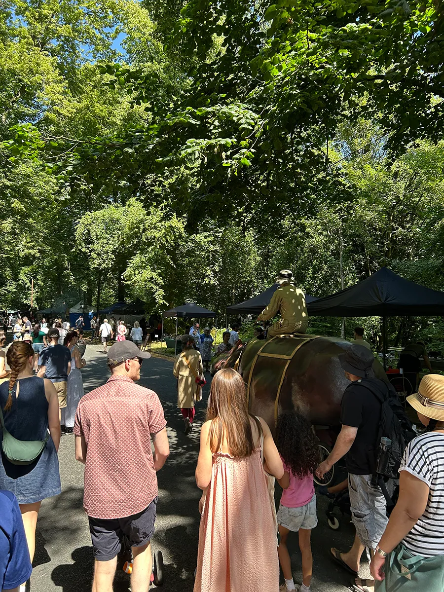 A crowd outside watching a robotic hippo