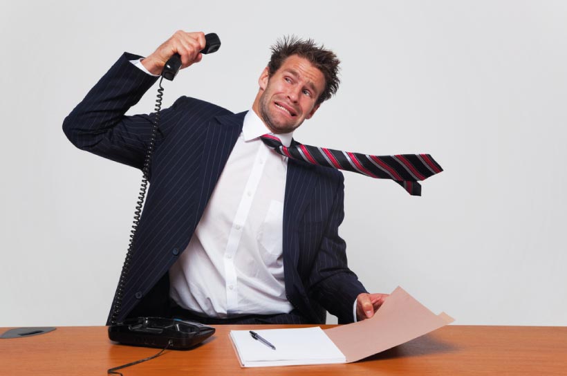 a man in a suit slamming a phone down