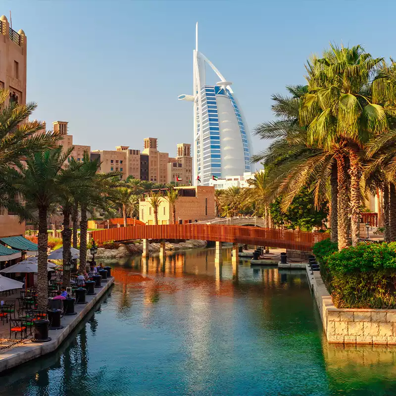 a hotel in Dubai with a waterfront and bridge in front of it